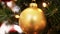 golden christmas ball decoration on fir tree