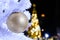 Golden christmas ball on fake white christmas tree with blur ba