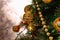 Golden Christmas decorations on a green artificial Christmas tree. Making a festive Christmas. Funny cute toys and gifts