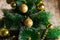 Golden Christmas decorations on a green artificial Christmas tree. Making a festive Christmas. Funny cute toys and gifts