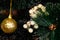 Golden Christmas decorations on a green artificial Christmas tree. Making a festive Christmas. Funny cute toys and gifts