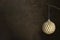 Golden Christmas ornament bauble sparkling decorative ball hanging, dark, moody background, copy space