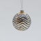 Golden Christmas tree ball covered with black zigzag patterns and glitter