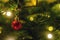 Golden Christmas tree ball decoration hanging on spruce branch surrounded be festive lights. Space for text