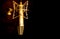 Golden color microphone detail in music and sound recording studio, black background, closeup