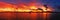 Golden colored coastal panoramic sunrise seascape cloudscape.