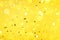 Golden confetti on yellow background with light bokehs. Happy new year celebration party. Greetings and congratulation concept.