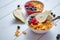 Golden cornflakes with fresh fruits of raspberries, blueberries and pear in ceramic bowl