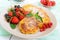 Golden cottage cheese pancakes with fresh berries on a plate on white wooden background.