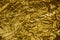 Golden creased metallic foil abstract bacgkground