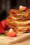 Golden crepes piled on a wooden board