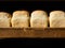 Golden, crisp, fresh bread on the wooden counter of a bakery or store. Homemade country bread, close-up. The concept of delicious