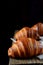 Golden croissants of yeast dough on the edge of the wooden table