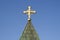 Golden cross on church over blue sky