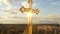 Golden cross of orthodox church with glitter on sky background