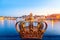 Golden crown on Skeppsholm bridge with illuminated Stockholm old city center Gamla Stan in the background during twilight sunset