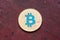 Golden cryptocurrency blue bitcoin on red background, cloose up.