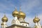 Golden cupolas with silvery crucifixes on onion domes of church