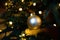 Golden decoration globe on christmas tree close up