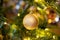 Golden decoration globe on christmas tree close up