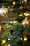 Golden decoration globe on christmas tree close up