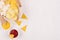 Golden different snacks on craft paper, triangles nachos, red and yellow sauce in bowl on soft white wood background.