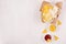 Golden different snacks on craft paper, triangles nachos, red and yellow sauce in bowl on soft white wood background.