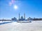 Golden-domed mosque with twin minarets against a clear blue sky. Sunlight Glistening on White Marble Mosque Minarets