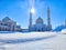 Golden-domed mosque with twin minarets against a clear blue sky. Sunlight Glistening on White Marble Mosque Minarets