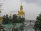 Golden domes of the Church of the Exaltation of the Holy Cross in nearby caves in the Kiev Pechersk Lavra in the rain