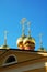 Golden domes and crosses on the roof of an Orthodox Church on a blue sky background. Russia.