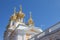 Golden domes and decoration of Peterhof Grand Palace against the bright sky