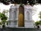 Golden door of a white Mausoleum of the Thai royal family in the Royal Cemetery of Wat Ratchabophit temple in Bangkok