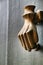 Golden doorknocker with hand shape on old green wooden door