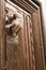 Golden doorknocker with hand shape on old wooden door