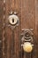 Golden doorknocker with modernist style on old wooden door