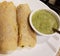 Golden dosa served on white plate with coconut chutney and mint coriander chutney.