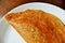 Golden dosa on white plate