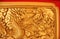 Golden dragon decorated on red wood wall