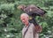 Golden eagle with dark brown, with lighter golden-brown plumage on the napes on the falconer hand. Birds for falconry