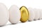 Golden egg around white eggs in row. Golden egg closeup. Golden egg as a sign of wealth, luxury. Egg as a symbol of