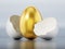 Golden egg inside regular white egg shell. 3D illustration