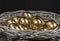 Golden eggs lie in a silver basket, close-up