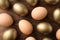 Golden eggs among others on wooden background