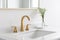 A golden faucet on a white marble countertop.