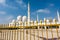 Golden fence and blurred background of the white Grand Mosque built with marble stone against blue sky, also called Sheikh Zayed