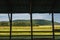 Golden Field and Mountains Framed by Barn Posts and Fence