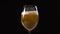 Golden foamy beer is poured slowly to the glass, beer glass in dark background, bubbles in beer, light beer