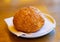 Golden fresh bun with sesame seeds on white plate