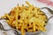 Golden fried french fries with melted cheddar cheese, known as cheesy fries